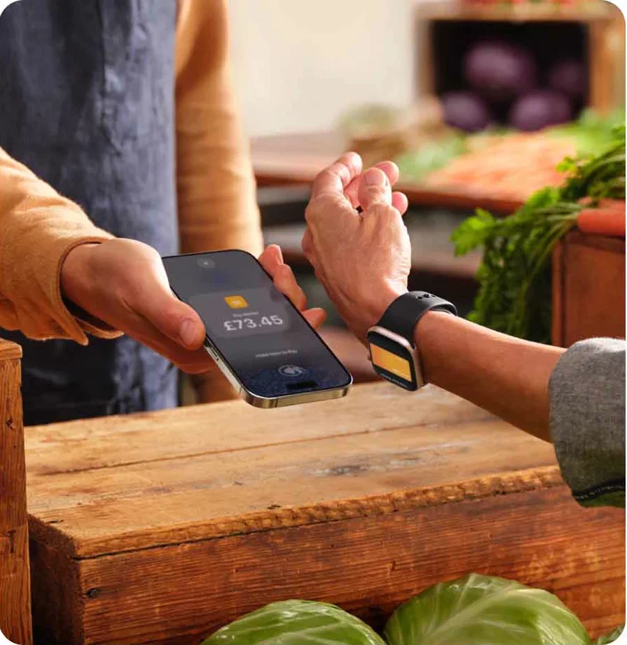 A stallholder taking a contactless payment on an iPhone at a market stall