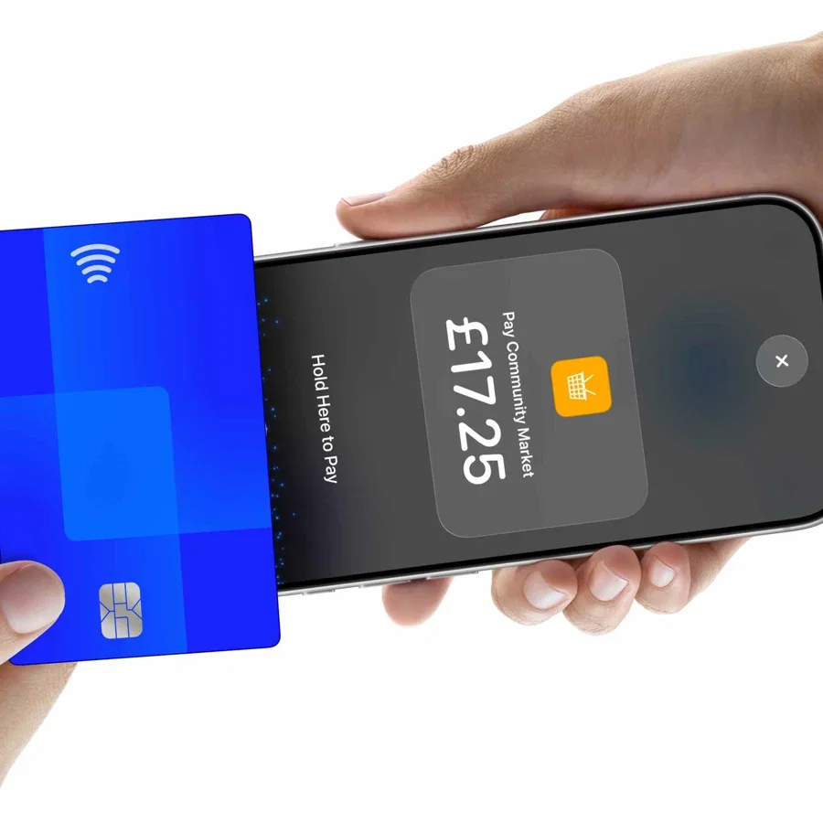 A customer holding a contactless card to the top of a merchant's iPhone