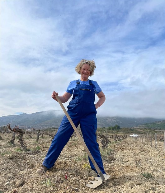 Katie Jones standing in a vineyard with a Tuchan rake