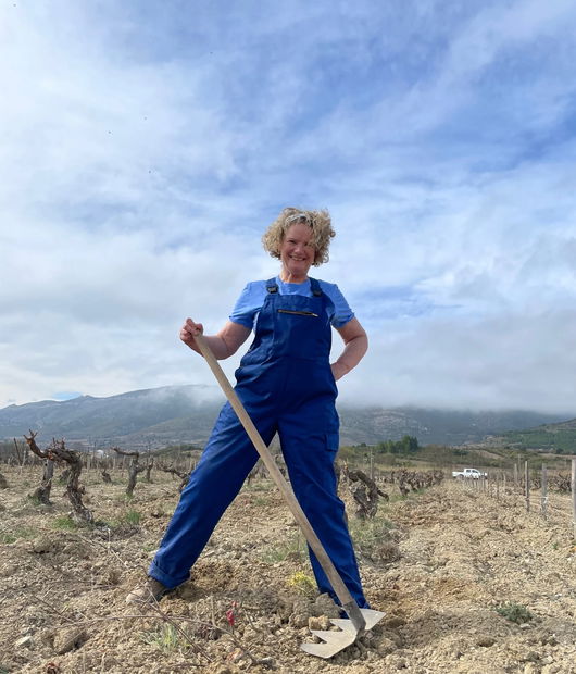 Katie Jones standing in a vineyard with a Tuchan rake